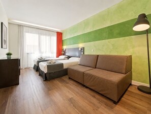 A modern hotel room with a sofa, a bed, a desk, and a lamp. - Studio apartment for 4 people near Retiro and Serrano (Madrid)