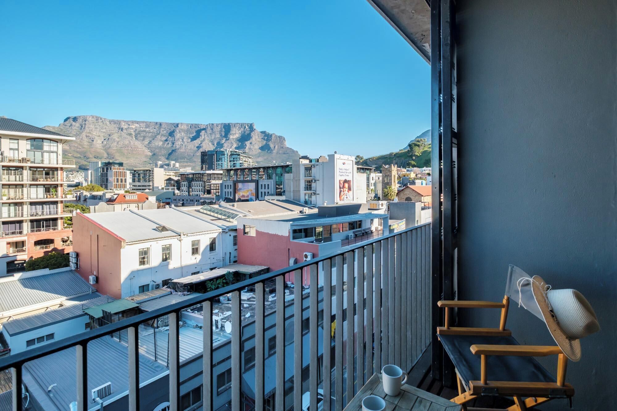 Een balkon met uitzicht op een stadslandschap en bergen.