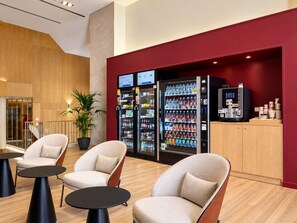 A modern lobby with seating, vending machines, and a reception area. - Comfort and functionality right next to the Retiro Park (Madrid)