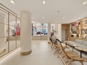 A modern interior with a central column, seating area, and a bookshelf. - Comfort and functionality right next to the Retiro Park (Madrid)