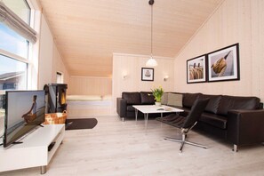 Ein modernes Wohnzimmer mit einer Couch, einem Couchtisch und einem Fernseher.