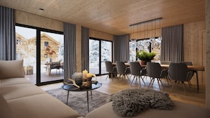 Un interior moderno con techo de madera, una zona de comedor con mesa y sillas de madera, y una acogedora sala de estar con sofá y alfombra.