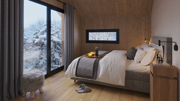 Un dormitorio con un ventanal grande, techo de madera y una cama con almohadas y una colcha.