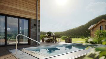 Ein moderner Außenpool mit Glasbarriere, einer Holzterrasse und einer Steinmauer.