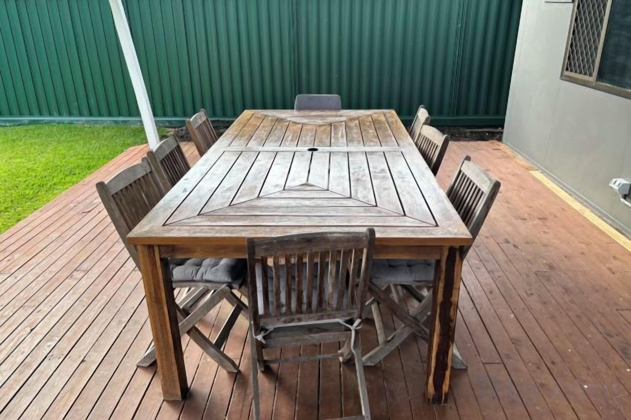 A wooden deck with a table and chairs.