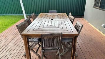A wooden deck with a table and chairs.