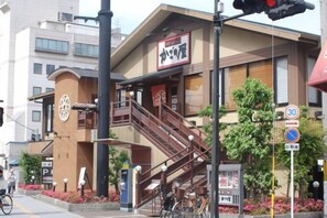 A building with a staircase leading to an entrance, a speed limit sign, and a no parking sign. - Travel Time - Senbon Naka (Osaka)