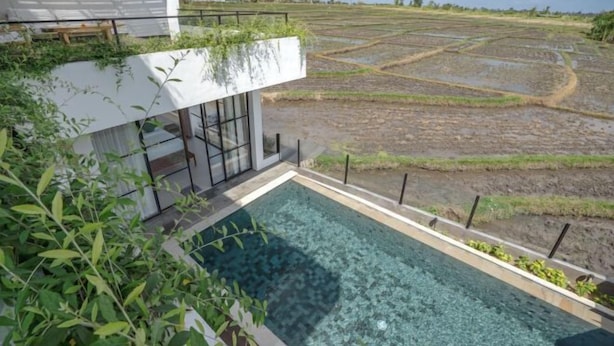A modern pool area with a view of agricultural fields.