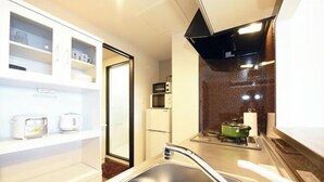 Una cocina compacta con un fregadero, estufa y microondas.