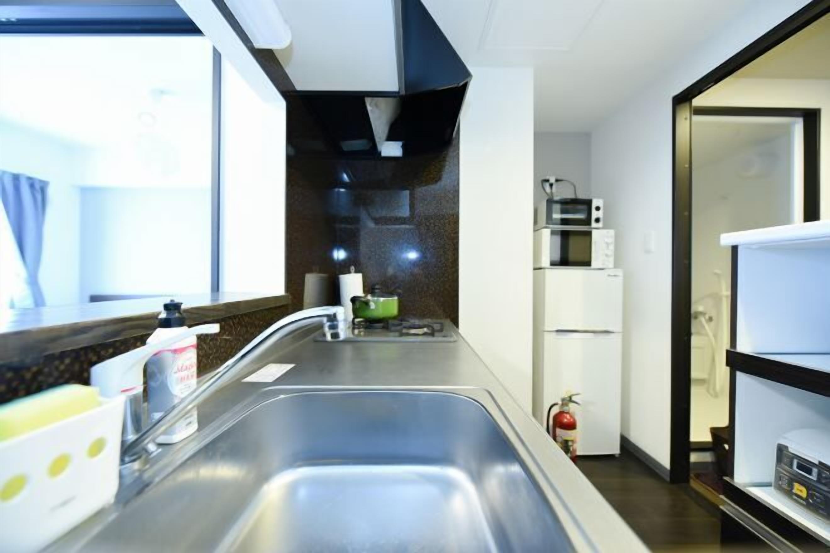 A kitchen with a double sink, a microwave, and a refrigerator.