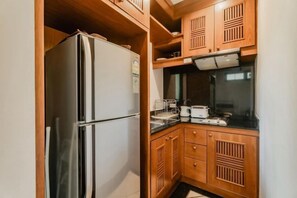 A compact kitchen with a refrigerator, wooden cabinets, and a countertop with a toaster. - Rose Pool Villa, The perfect private oasis (Phuket)