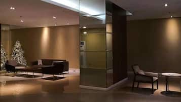 A modern interior with a glass partition, seating area, and a Christmas tree.
