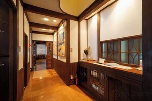 A hallway with wooden paneling, a reception desk, and framed pictures on the walls.