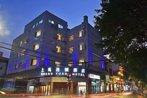 A multi-story hotel with illuminated signage, a prominent entrance, and a street view. - Shangyuan Hotel Chain (Guangzhou Thirteen Factories Yide Road Metro Station) (Guangzhou)