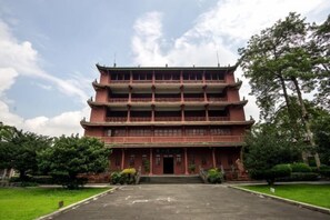 A multi-tiered traditional building with a symmetrical facade, a central entrance, and a surrounding green lawn. - Shangyuan Hotel Chain (Guangzhou Thirteen Factories Yide Road Metro Station) (Guangzhou)