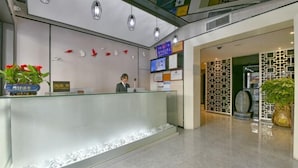 A reception area with a glass counter, a receptionist, and a reception desk. - Shangyuan Hotel Chain (Guangzhou Thirteen Factories Yide Road Metro Station) (Guangzhou)