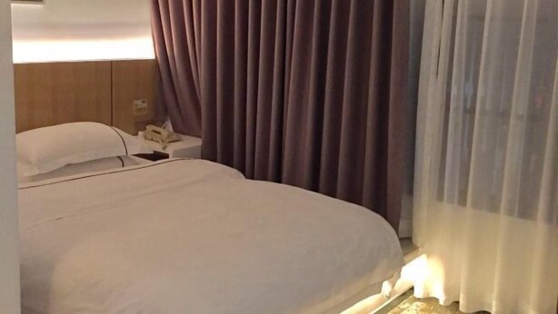 A hotel room with a bed, a bedside table, and a lamp. - Shangyuan Hotel Chain (Guangzhou Thirteen Factories Yide Road Metro Station) (Guangzhou)
