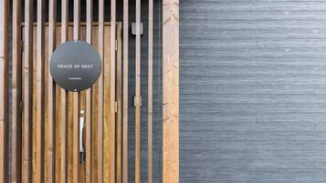 A door with a sign that reads 'PEACE OF REST' and a vertical wooden slat design.