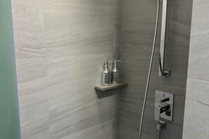 A shower area with a built-in shelf holding toiletries, a handheld showerhead, and a control panel. - The Edge Central Pattaya - infinity pool with sea view (Pattaya)