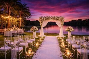 Preparación para una ceremonia de boda con un arco floral y sillas dispuestas para los invitados.