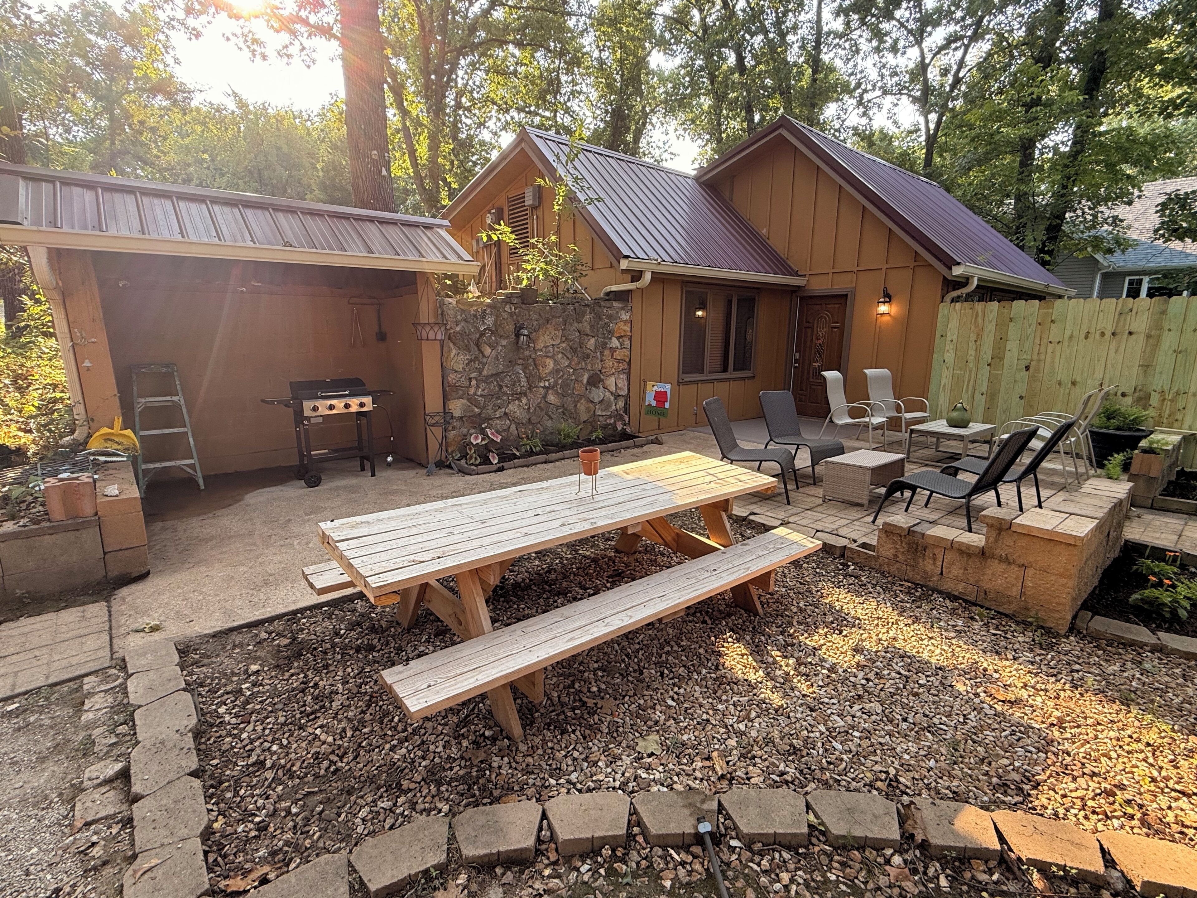 A backyard with a wooden deck, a barbecue grill, and outdoor seating.