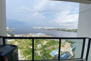 A room with a large window overlooking a river and distant cityscape. - R&F Princess Cove Boutique Homestay By TREX #Nearby CIQ #Johor Bahru #JB Central (Johor Bahru)