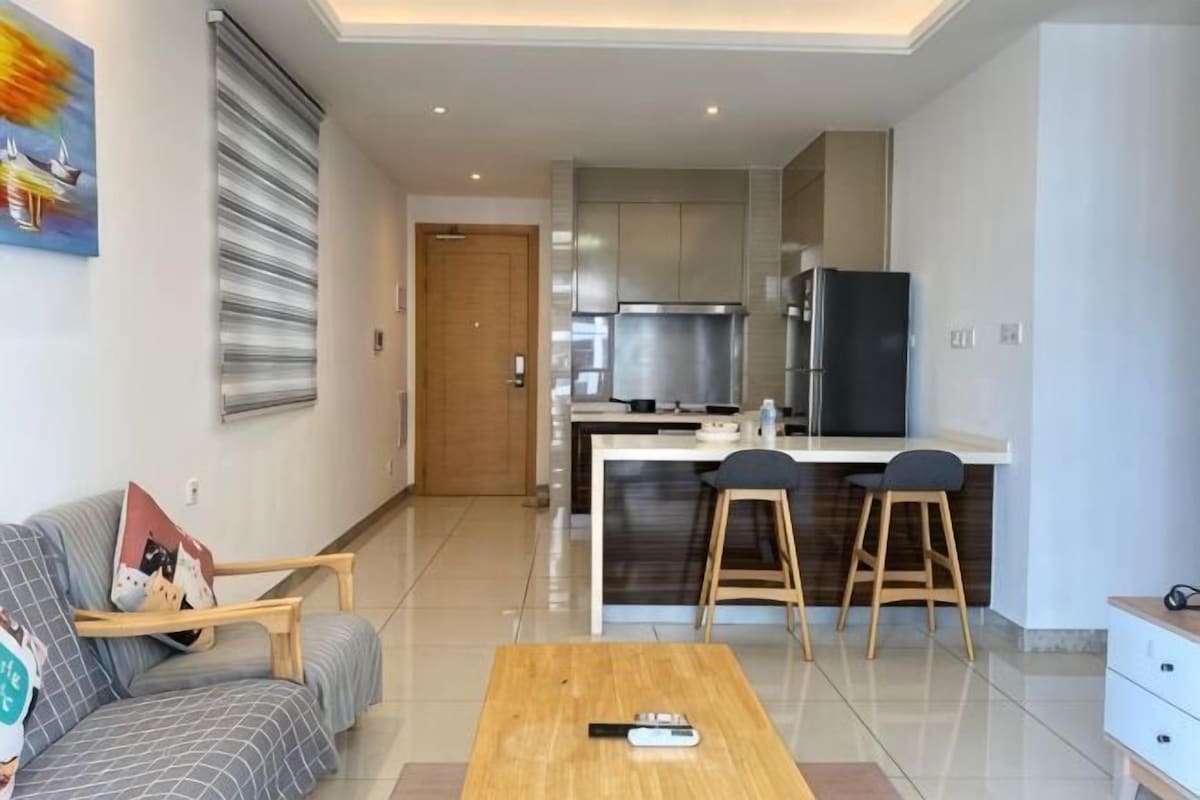 A modern apartment with a living room, kitchen, and dining area.