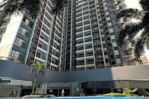 A high-rise residential building with multiple balconies, a swimming pool, and palm trees. - R&F Princess Cove Boutique Homestay By TREX #Nearby CIQ #Johor Bahru #JB Central (Johor Bahru)