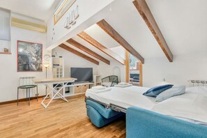 Un dormitori modern tipus loft amb un llit, un escriptori i una cadira.