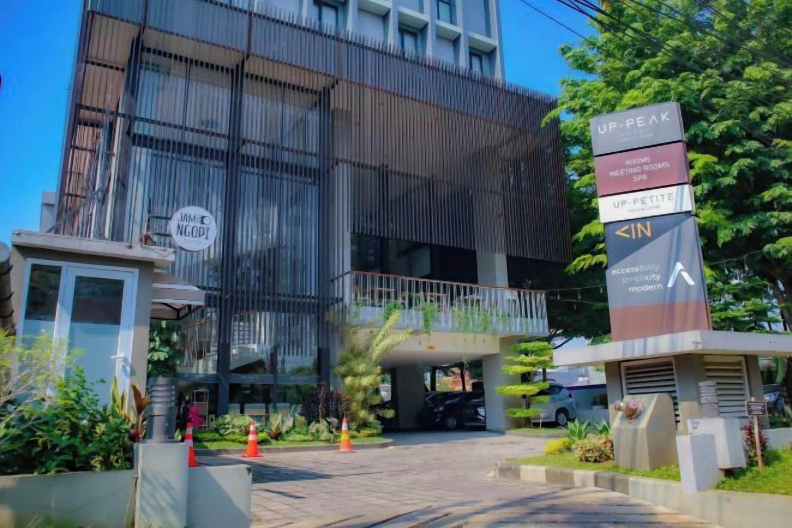 A modern building with a sign indicating 'UP PEAK' and 'IN' for access.