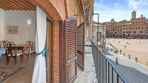Ein Balkon mit Blick auf einen Strand und historische Gebäude.