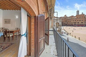 Ein Balkon mit Blick auf einen Strand und historische Gebäude.