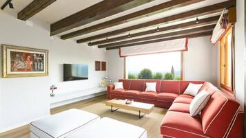 Departamento Deluxe, vista al viñedo | Área de sala de estar | Televisión LED de 50 pulgadas con canales digitales