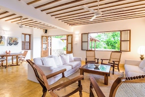 A spacious living area with a white sofa, wooden chairs, a coffee table, and a ceiling fan. - Cinnamon House, Weligama by The Serendipity Collection (Weligama)