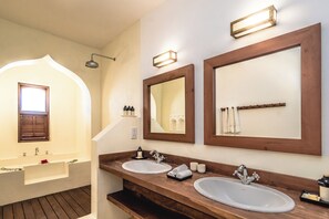 Un baño con dos lavamanos, una ducha y un espejo grande.
