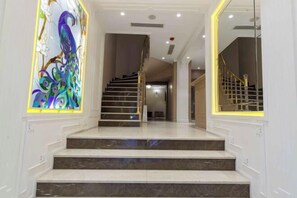 Una escalera conduce a un segundo piso con una puerta de cristal a la derecha.
