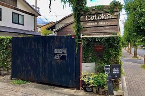 A rustic wooden sign for Cotohana Green Shop, a signboard for Lager, and a CLAMP coffee sign.