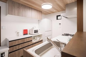 A compact kitchen with a sink, stove, microwave, and cabinets.