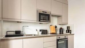 Eine moderne Küche mit integriertem Mikrowellenherd, einer Kaffeemaschine und einem Toaster.