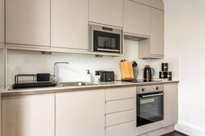 A modern kitchen with a built-in microwave, a coffee maker, and a toaster. - 20 West Street BN1 2RS (Brighton and Hove)