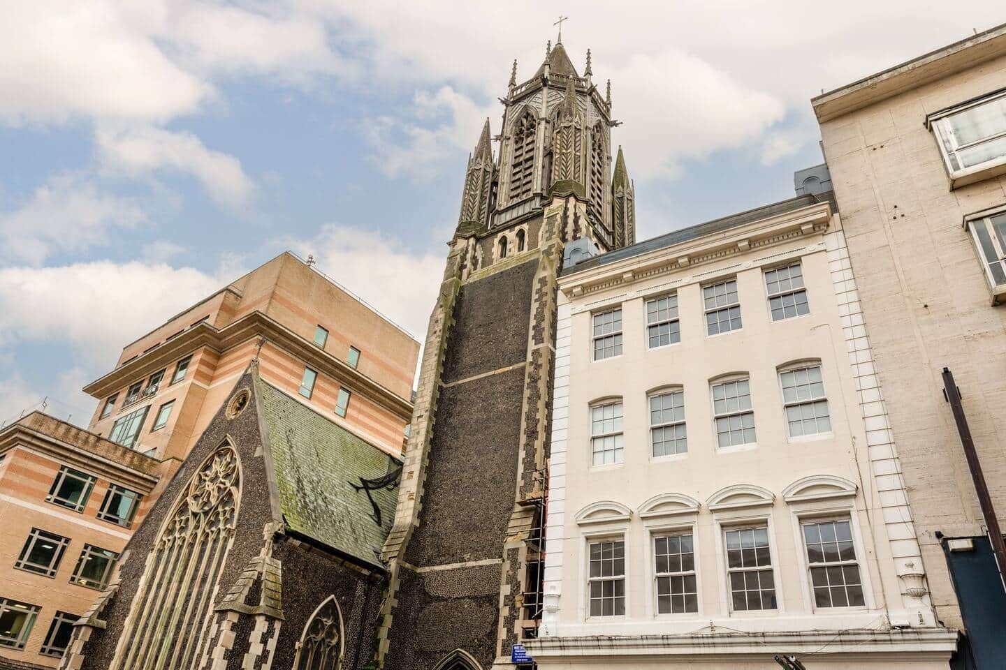 Un bâtiment historique doté d’une tour imposante et d’une grande fenêtre en arc de cercle.