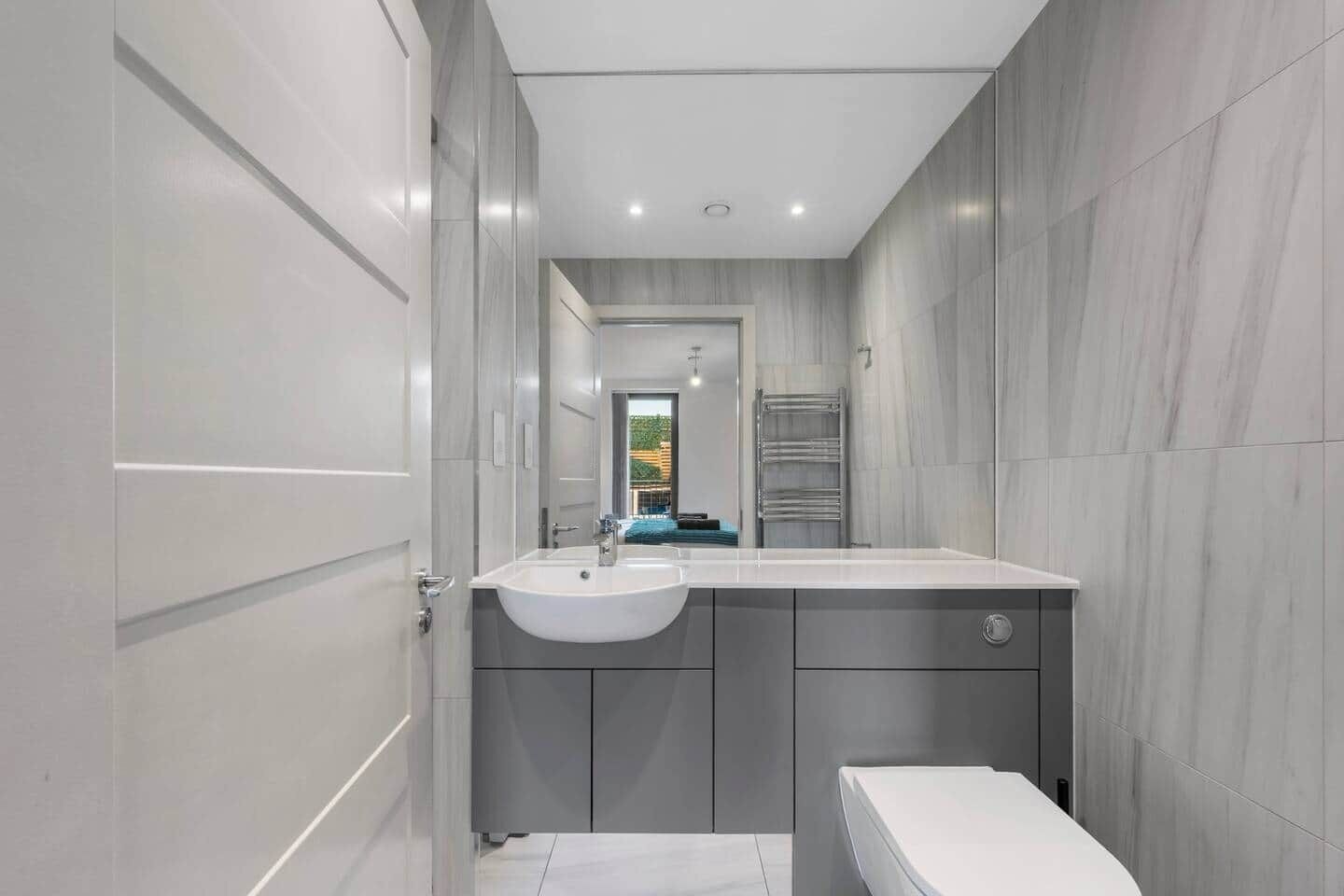 Un baño moderno con lavamanos integrado, inodoro y zona de ducha.