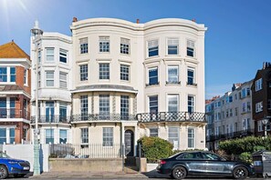 Un immeuble à plusieurs étages doté d’une façade incurvée, de nombreuses fenêtres et de balcons.