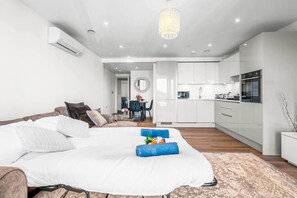 A modern bedroom with a large bed, a dining area, and a kitchen. - Flat 5, Brentford TW8 9NA (Brentford)