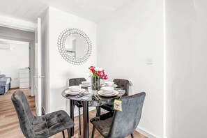 A dining area with a round table, four chairs, and a vase of flowers. - Flat 5, Brentford TW8 9NA (Brentford)