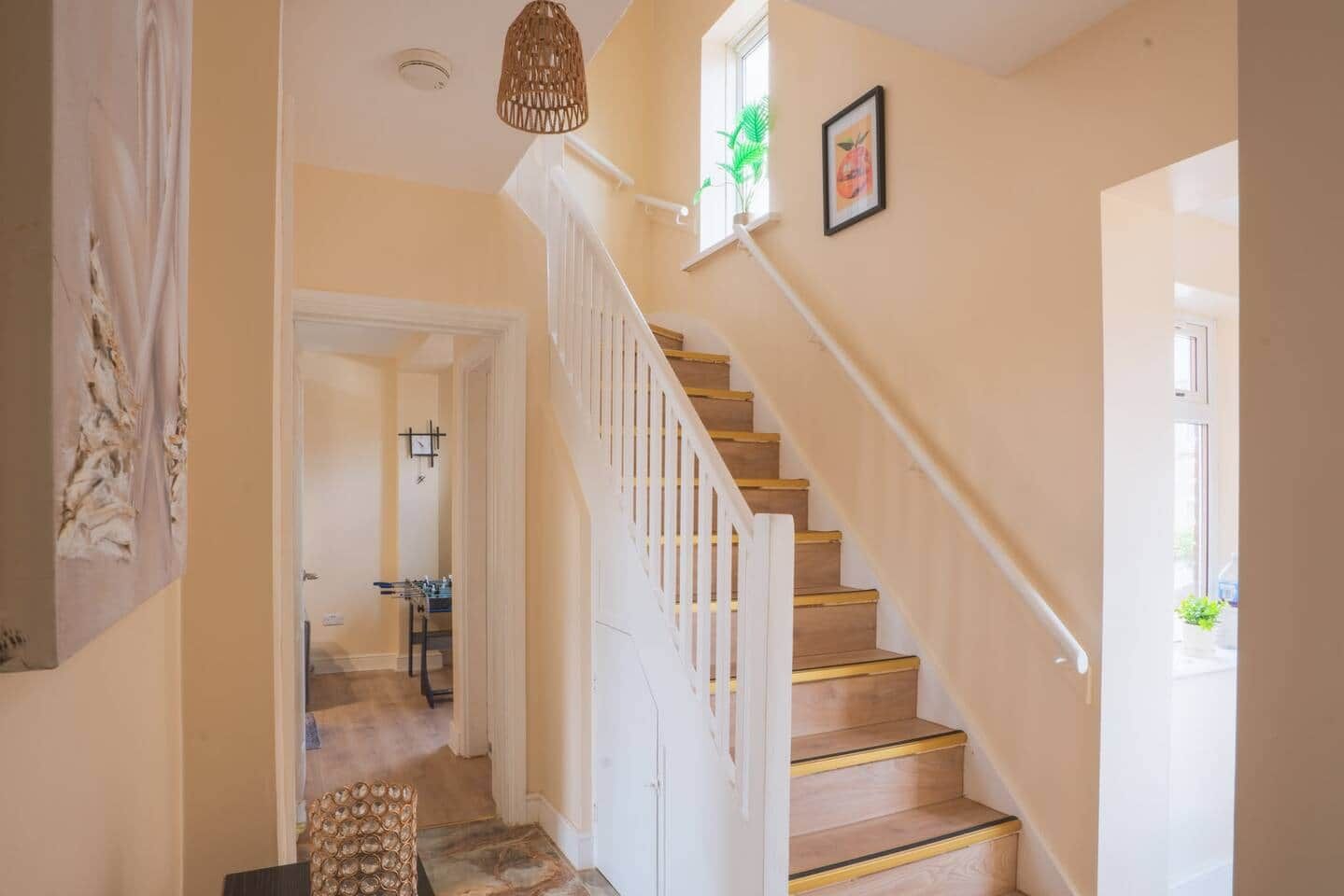 A staircase with white railings and wooden steps leading to an upper floor.