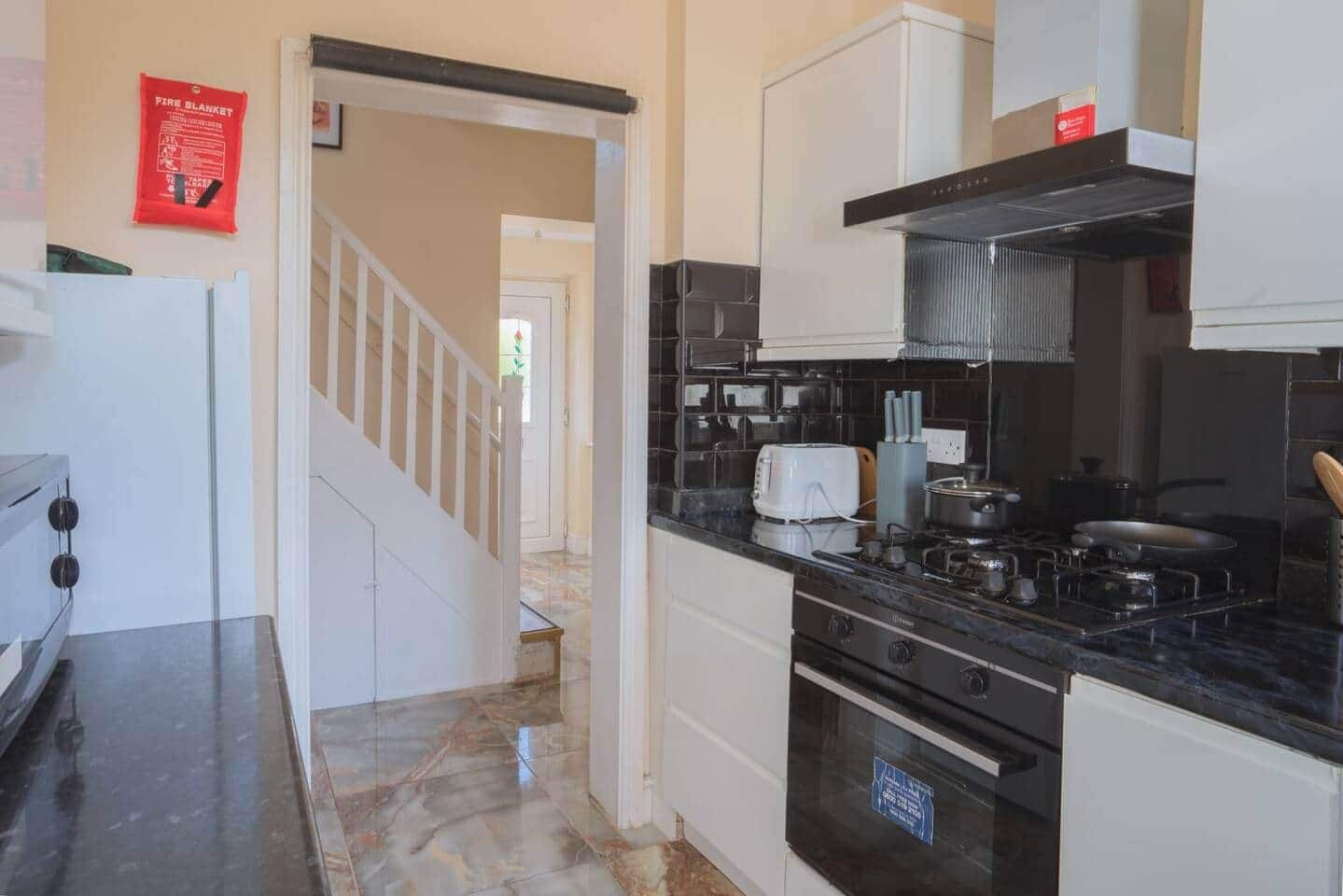 A kitchen with a stove, oven, and a toaster on the counter.