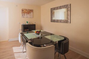 A dining area with a glass-top table, black chairs, a fruit bowl, and a decorative mirror on the wall. - Fenham, Newcastle NE4 (Newcastle upon Tyne)