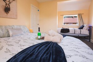A hotel room with a bed, a sofa, a door, and a window with a view of a building. - Fenham, Newcastle NE4 (Newcastle upon Tyne)
