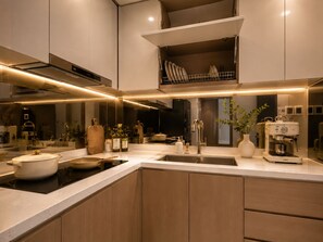 Una cocina moderna con horno empotrado, un lavamanos y una cafetera.